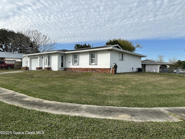 ranch-style house featuring central air condition unit, a front lawn, and a garage