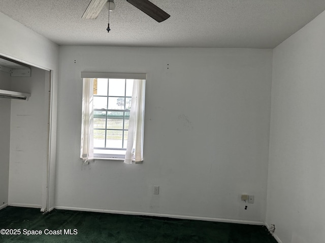 unfurnished bedroom with ceiling fan, a closet, a textured ceiling, and dark colored carpet