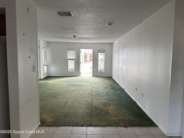 unfurnished room featuring a textured ceiling and light colored carpet