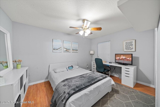 bedroom with a textured ceiling, ceiling fan, dark hardwood / wood-style flooring, and a closet