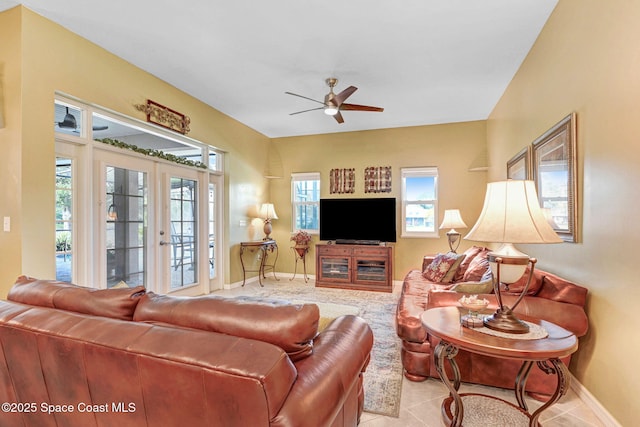 tiled living room with ceiling fan and french doors