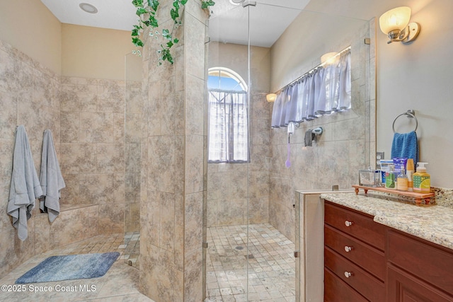 bathroom with vanity and a tile shower