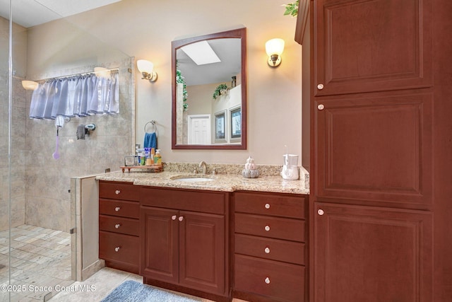 bathroom featuring tile patterned floors, tiled shower, and vanity