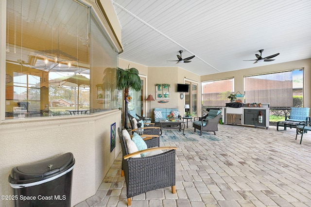 view of patio with ceiling fan, an outdoor living space, and exterior kitchen