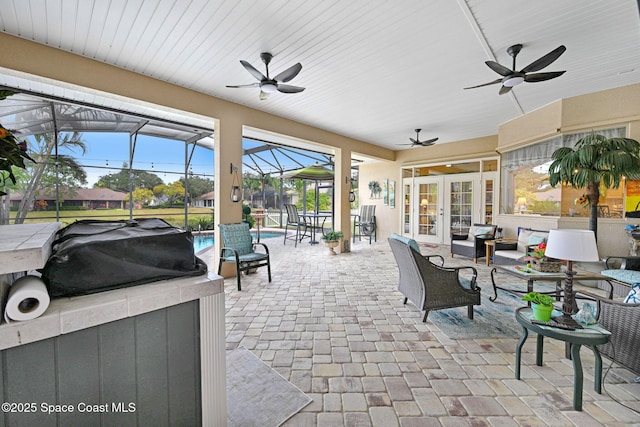 view of patio featuring ceiling fan, a lanai, and french doors