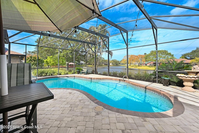 view of swimming pool featuring a water view, a patio area, and a lanai