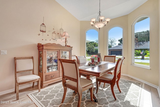 dining room with vaulted ceiling, light hardwood / wood-style floors, plenty of natural light, and a notable chandelier