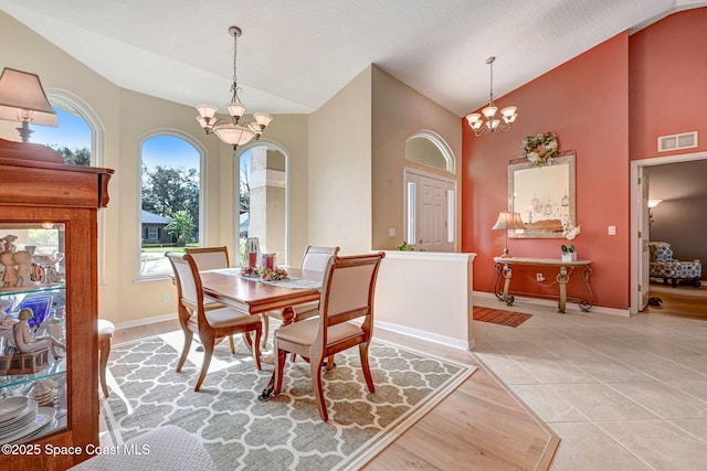 dining room featuring high vaulted ceiling, light tile patterned floors, and a chandelier