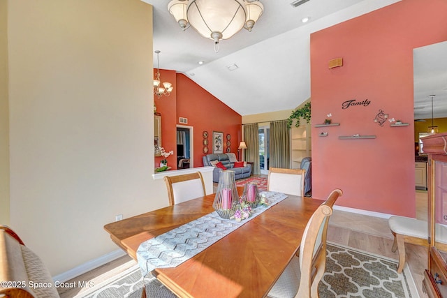 dining area with lofted ceiling and an inviting chandelier