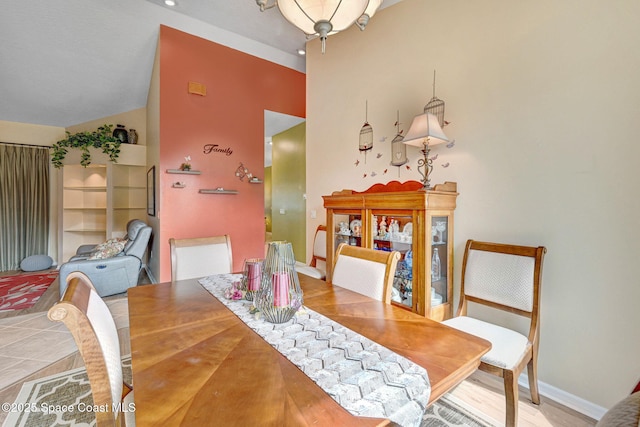 dining area with tile patterned flooring and vaulted ceiling