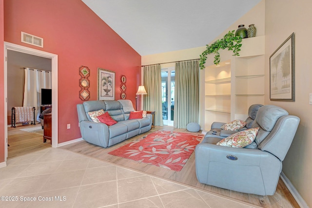 living room featuring high vaulted ceiling and built in features