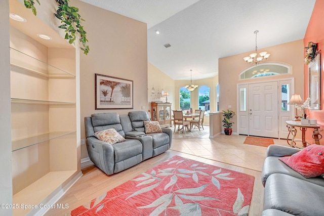 living room featuring vaulted ceiling, a chandelier, and light hardwood / wood-style floors