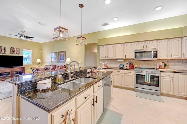 kitchen with stainless steel appliances, a kitchen island with sink, decorative light fixtures, and sink