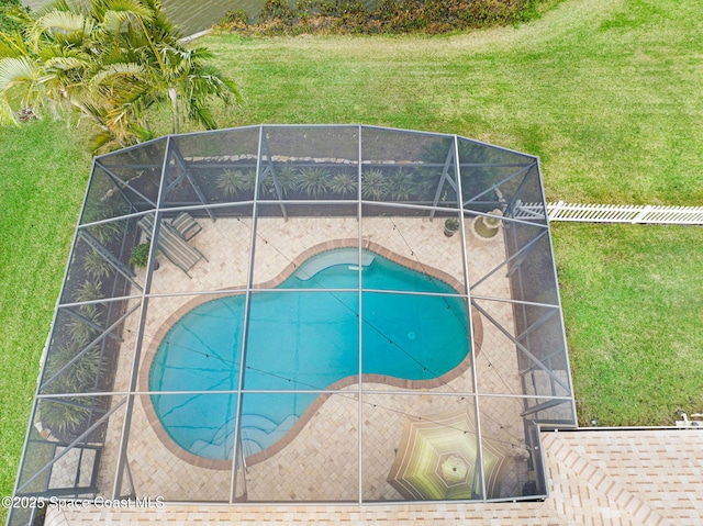 view of swimming pool featuring a patio area, a lanai, and a yard