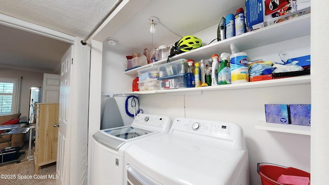 laundry area featuring a textured ceiling, separate washer and dryer, and ornamental molding