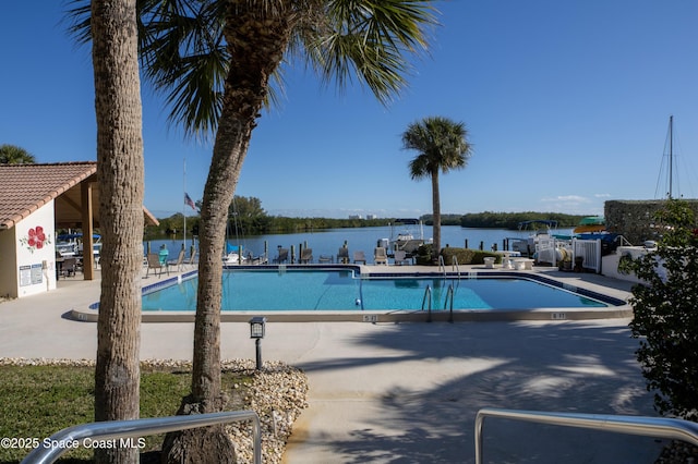 view of swimming pool with a water view and a patio