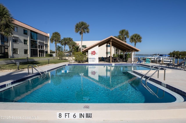 view of pool featuring a water view and a patio area