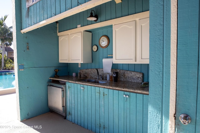 kitchen featuring dishwasher, sink, blue cabinetry, and white cabinetry