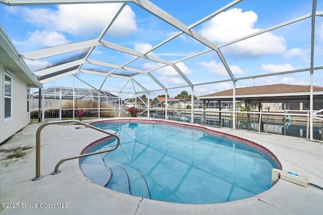 view of swimming pool with a patio area, glass enclosure, and a water view