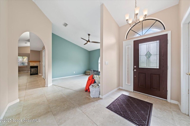 foyer with ceiling fan with notable chandelier and lofted ceiling