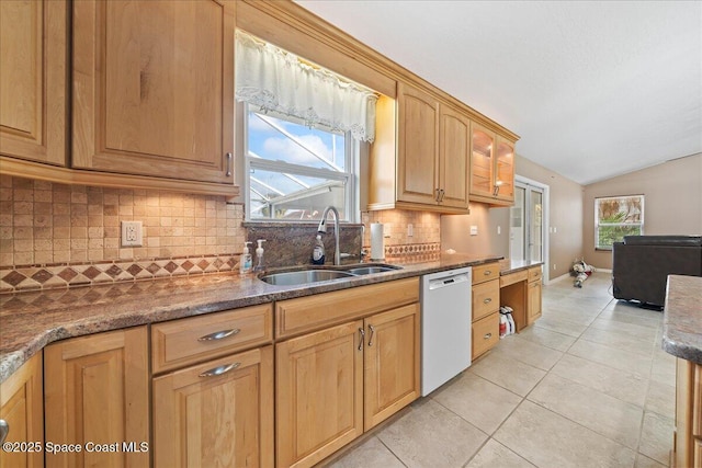 kitchen with dishwasher, a wealth of natural light, light tile patterned floors, lofted ceiling, and sink