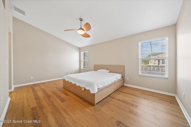 bedroom with ceiling fan, light hardwood / wood-style floors, and multiple windows