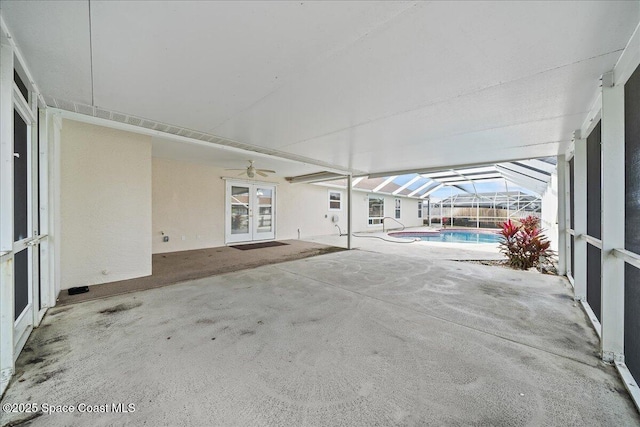 view of patio / terrace featuring ceiling fan and glass enclosure