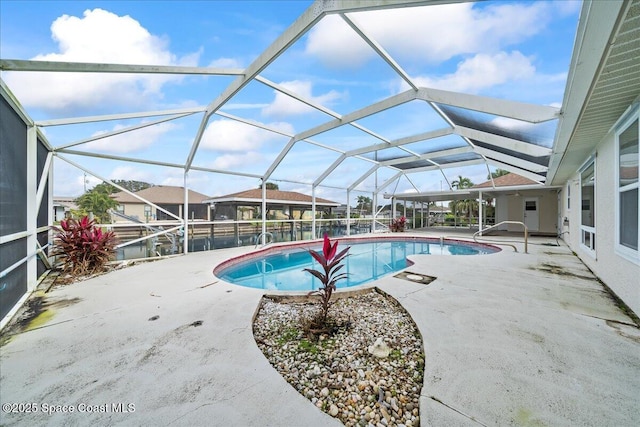 view of swimming pool featuring a patio and glass enclosure