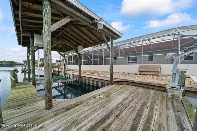 dock area with a lanai and a water view