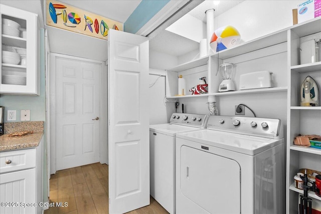 laundry room featuring light wood-type flooring and washing machine and clothes dryer