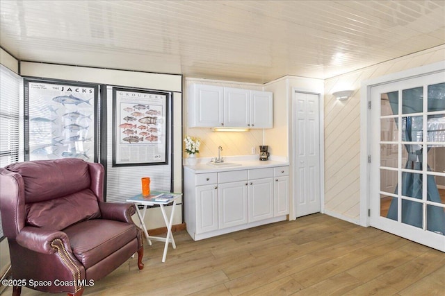 interior space featuring sink, white cabinetry, and light hardwood / wood-style floors