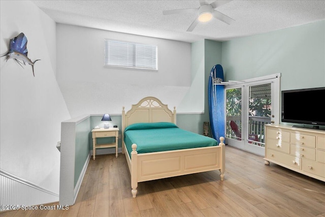 bedroom with light wood-type flooring, ceiling fan, a textured ceiling, and access to exterior