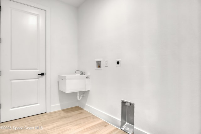 clothes washing area featuring washer hookup, light hardwood / wood-style flooring, and electric dryer hookup