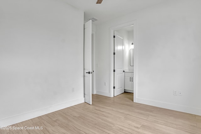 unfurnished bedroom with ceiling fan, connected bathroom, and light hardwood / wood-style flooring