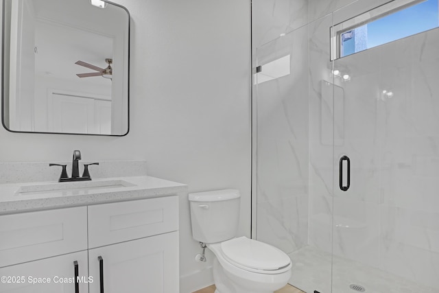 bathroom featuring ceiling fan, vanity, toilet, and a shower with door