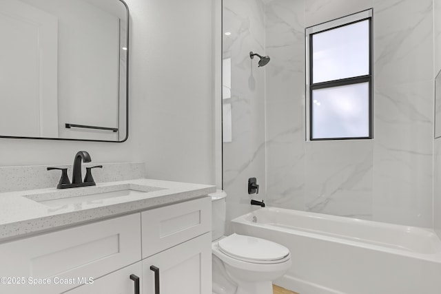 full bathroom featuring tiled shower / bath, vanity, and toilet