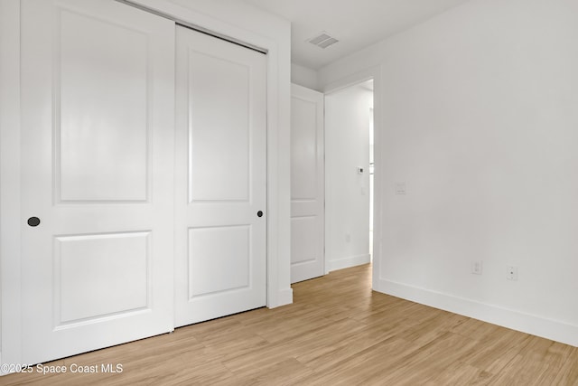 unfurnished bedroom featuring a closet and light wood-type flooring