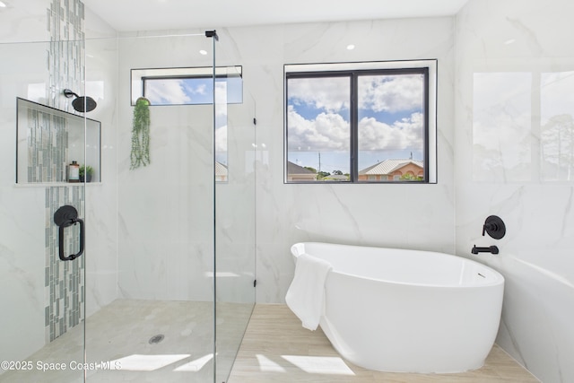 2311 San Filippo Dr SE, Palm Bay, FL 32909 - bathroom with tile walls, a freestanding tub, and a shower stall