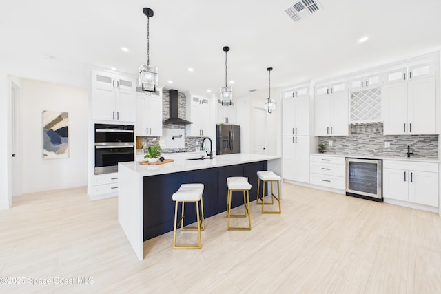2311 San Filippo Dr SE, Palm Bay, FL 32909 - kitchen with visible vents, stainless steel appliances, a sink, beverage cooler, and wall chimney range hood