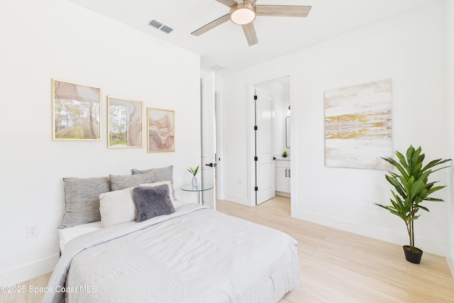 2311 San Filippo Dr SE, Palm Bay, FL 32909 - bedroom with baseboards, ensuite bath, visible vents, and light wood-type flooring