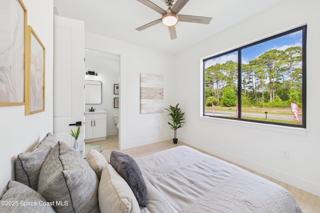 2311 San Filippo Dr SE, Palm Bay, FL 32909 - bedroom featuring baseboards, ensuite bathroom, light wood-style flooring, and a ceiling fan