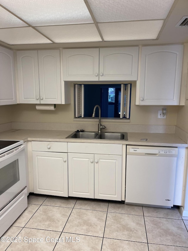 kitchen featuring light tile patterned floors, sink, white cabinets, and white appliances