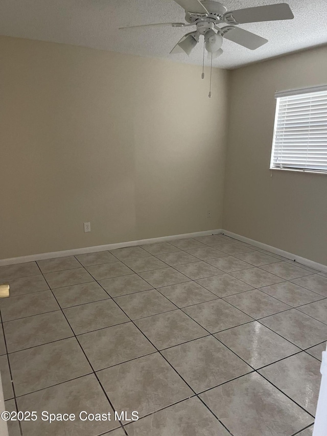 tiled spare room with ceiling fan and a textured ceiling