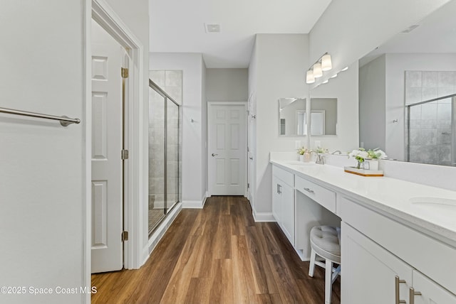 bathroom featuring a shower with door, vanity, and hardwood / wood-style floors