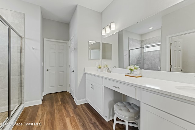 bathroom featuring wood-type flooring, walk in shower, and vanity