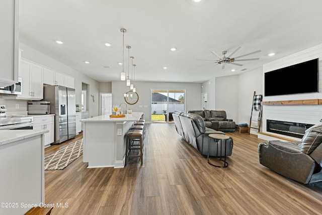 living room with ceiling fan and wood-type flooring