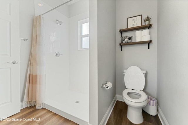 bathroom featuring toilet, walk in shower, and hardwood / wood-style flooring