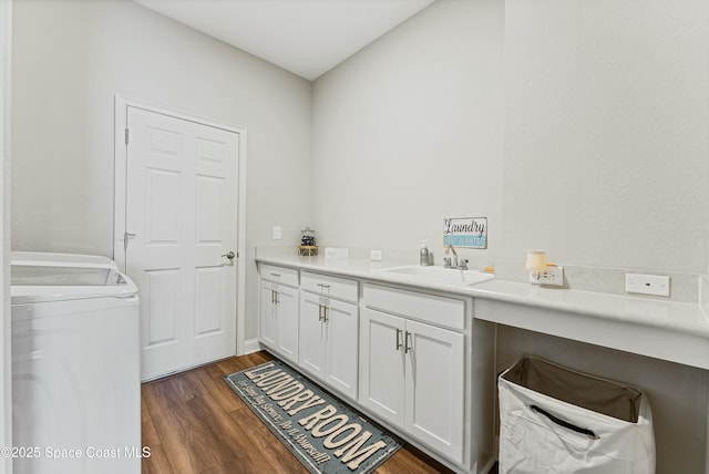 clothes washing area with sink and dark hardwood / wood-style flooring