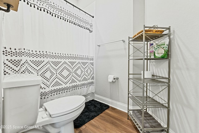 bathroom with toilet, hardwood / wood-style flooring, and walk in shower