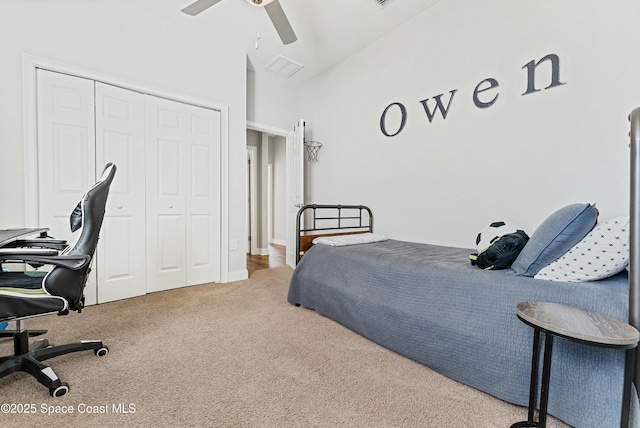 carpeted bedroom with ceiling fan, a closet, and vaulted ceiling